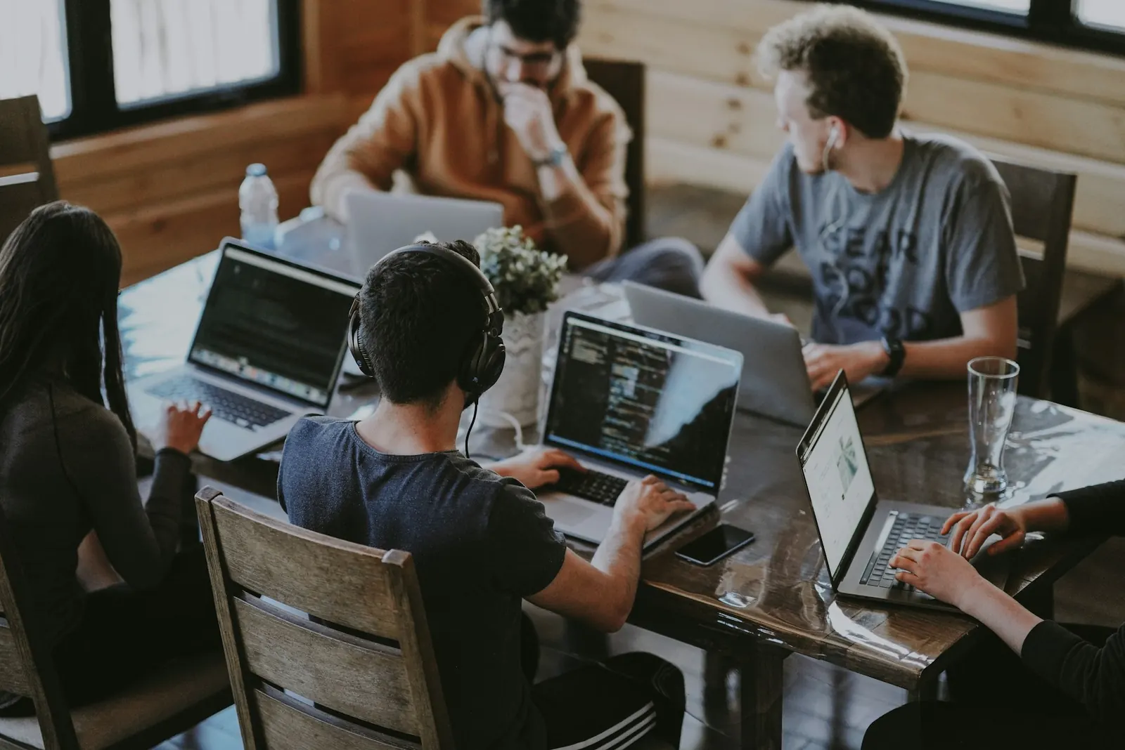 Software startup team collaborating around laptops